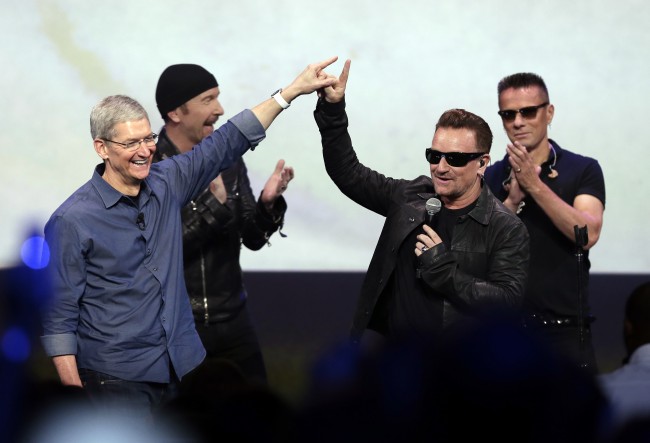 FILE - In this Sept. 9, 2014 file photo, Apple CEO Tim Cook, left, greets Bono from the band U2 after they preformed at the end of the Apple event on Tuesday, Sept. 9, 2014, in Cupertino, Calif. Apple unveiled a new Apple Watch, the iPhone 6 and Apple Pay and U2 offered iTunes customers a free download of their latest album, "Songs of Innocence." (AP Photo/Marcio Jose Sanchez)