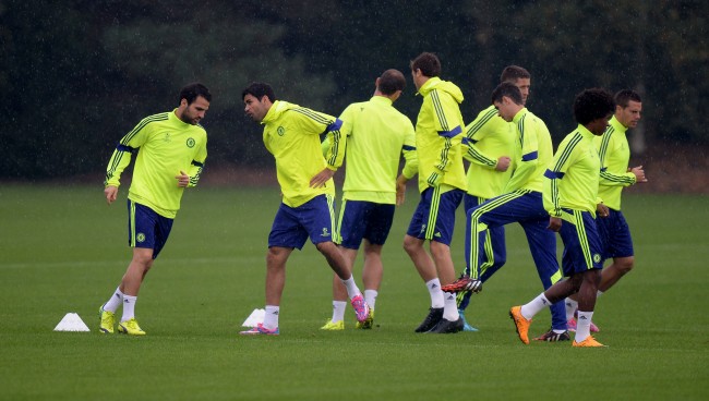 Chelsea's Cesc Fabregas (left) and Diego Costa (second left) warm up with their team mates during a training session at Cobham Training Ground, Surrey. Picture date: Monday September 29, 2014,