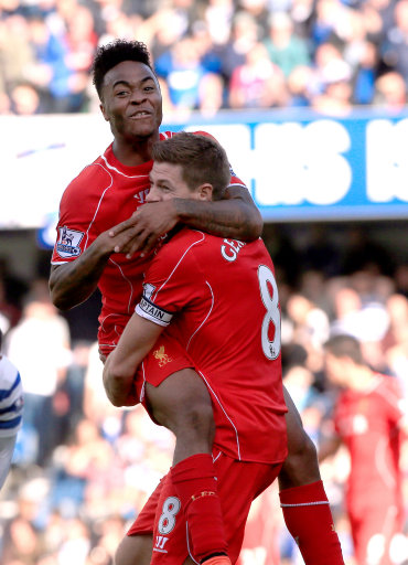 Liverpool's Raheem Sterling celebrates with his team-mate Steven Gerrard after his cross is put into the net for an own-goal by Queens Park Rangers' Steven Caulker (not in picture) during the Barclays Premier League match at Loftus Road, London. Picture date: Sunday October 19, 2014. 