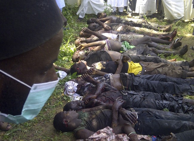 In this image taken with a mobile phone, rescue workers and family members gather to identify the bodies of students killed following an attack by Islamist extremist on an agricultural college in Gujba, Nigeria, Sunday, Sept. 29, 2013, Suspected Islamic extremists attacked the Yobe State College of Agriculture early Sunday, gunning down students as they slept in dormitories and torching classrooms, leaving some 50 students dead in the attack according to college Provost Molima Idi Mato. The attack is seen as part of an ongoing Islamic uprising in northeastern Nigeria prosecuted by Boko Haram militants in their declared quest to install an Islamic state. (AP Photo)