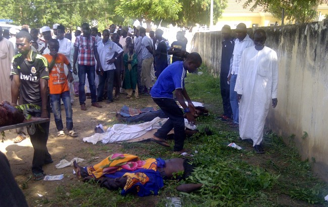n this image taken with a mobile phone, rescue workers and family members gather to identify the shrouded bodies of students killed following an attack by Islamist extremist on an agricultural college in Gujba, Nigeria, Sunday, Sept. 29, 2013, Suspected Islamic extremists attacked the Yobe State College of Agriculture early Sunday, gunning down students as they slept in dormitories and torching classrooms, leaving some 50 students dead in the attack according to college Provost Molima Idi Mato. The attack is seen as part of an ongoing Islamic uprising in northeastern Nigeria prosecuted by Boko Haram militants in their declared quest to install an Islamic state. (AP Photo)