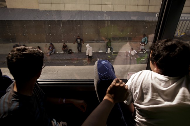 Young volunteers from the Dream Center, a Christian church mission, look at homeless people from inside their bus in the Skid Row area of Los Angeles on Thursday, July 18, 2013. (AP Photo/Jae C. Hong)