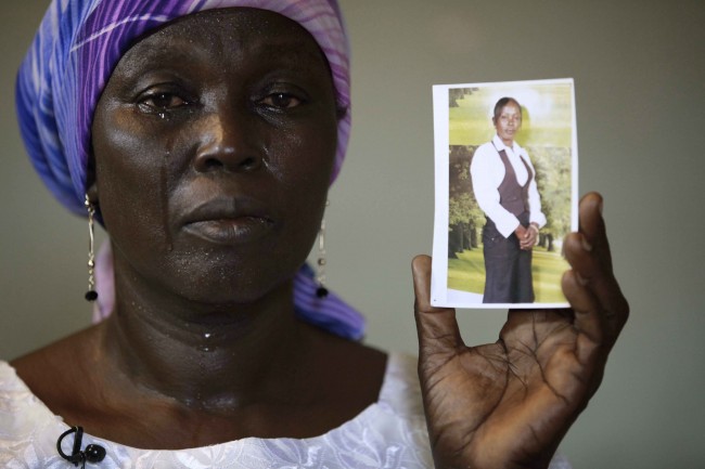 In this photo taken on Monday, May 19, 2014. Martha Mark, the mother of kidnapped school girl Monica Mark cries as she display her photo, in the family house, in Chibok, Nigeria. More than 200 schoolgirls were kidnapped from a school in Chibok in Nigeria's north-eastern state of Borno on April 14. Boko Haram claimed responsibility for the act. (AP Photo/Sunday Alamba)