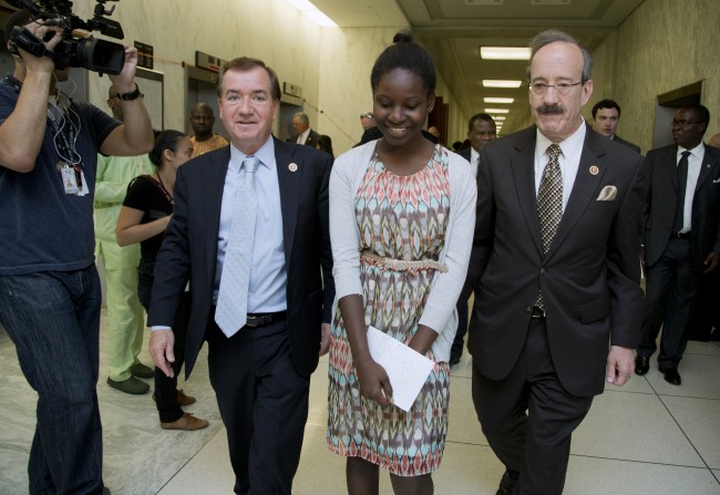 Deborah Peter, center, walks with House Foreign Affairs Committee Chairman Rep. Ed Royce, R-Calif., left, and, the committee's ranking member Rep. Eliot Engel, D-N.Y. to a hearing room on Capitol Hill in Washington, Wednesday, May 21, 2014, following a news conference. Peter, is a sole survivor of a Dec. 11, 2011, Boko Haram attack on her household in Nigeria, where her father and brother were killed for not renouncing their Christian faith. (AP Photo/Manuel Balce Ceneta) 