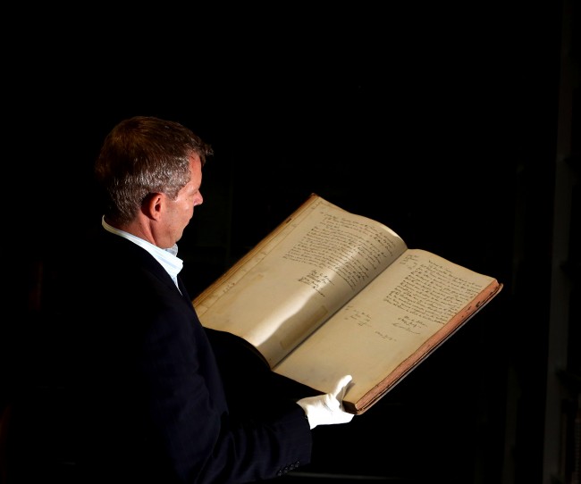 Lead researcher Professor Peter Stoneley from the University of Reading, looks at a record of visits of the justices to Reading Prison opened to the page of July 10th 1896,