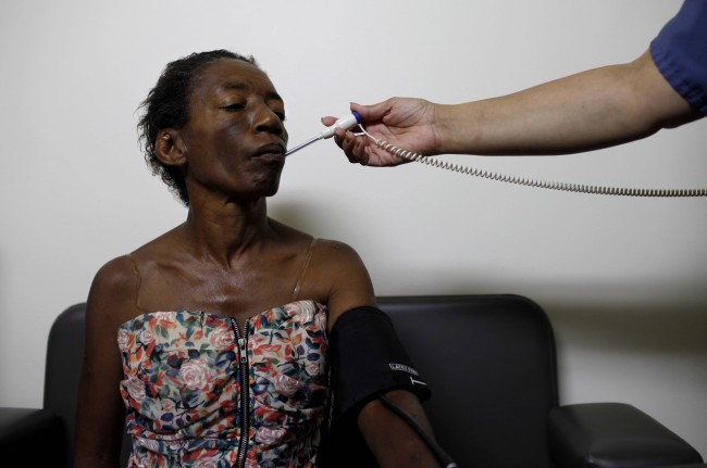 Sheila Nichols, 55, has her temperature checked by a nurse at a clinic in Los Angeles, Monday, July 19, 2010. After two decades living on the streets of Skid Row, Nichols was dying. Her body had wasted away to 61 pounds, ravaged by a heavy-duty crack cocaine addiction, hepatitis, HIV, and late-stage syphilis. Nichols was rescued by Project 50, a pilot program to get the 50 people most likely to die if they remained homeless into housing, medical care and social services. (AP Photo/Jae C. Hong) 