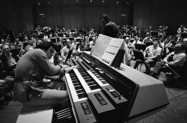 Lalo Schifrin, Argentine-born composer, rehearses his electronic music-making monster called the Electronic EX-42 with the Los Angeles Philharmonic under Zubin Mehta's direction for the world premiere of his "Pulsations", Jan. 27, 1971. The contrivance is part of an electronic musical explosion with widespread implications for producers and musicians. (AP Photo/George Brich)