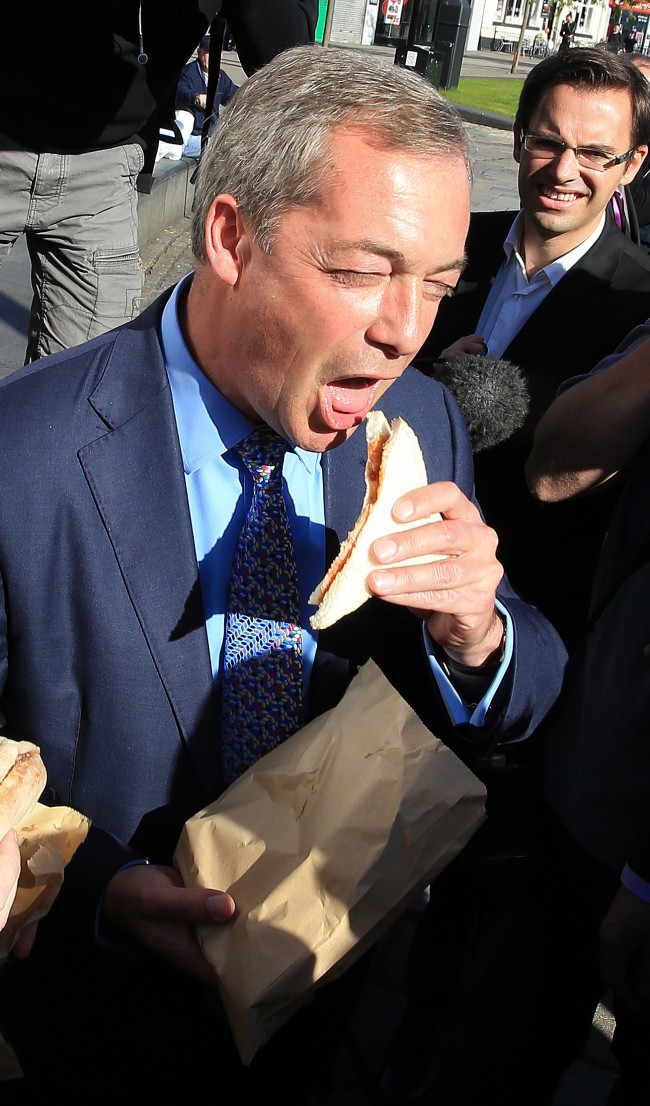 Leader of the Ukip party Nigel Farage eating a bacon sandwich during a visit to the Heywood and Middleton constituency ahead of the by-election next week. Picture date: Thursday October 2, 2014. See PA story POLITICS Middleton. Photo credit should read: Peter Byrne/PA Wire Ref #: PA.21080796  Date: 02/10/2014 