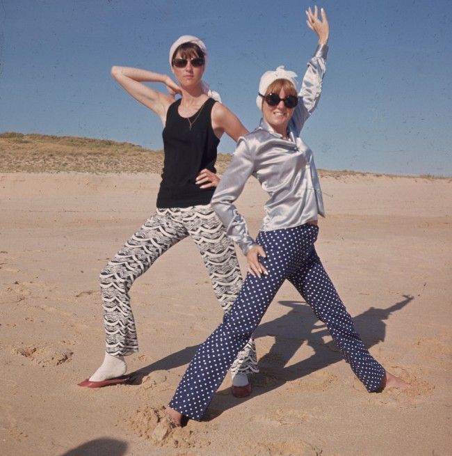 circa 1965:  L to r. TV presenter Cathy McGowan and  on right, pop star and TV show hostess Cilla Black  posing on the beach while on holiday in Portugal.  (Photo by Hulton Archive/Getty Images)