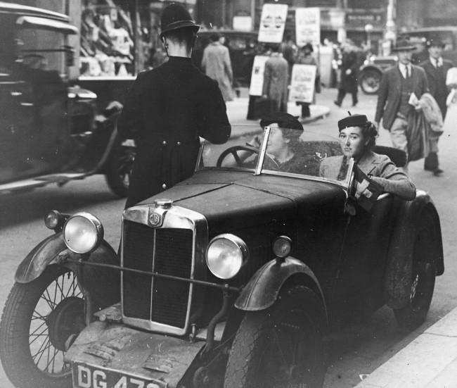 London motorists in an MG M-type receive a ticket from a traffic policeman on the corner of Wardour Street.    (Photo by General Photographic Agency/Getty Images)