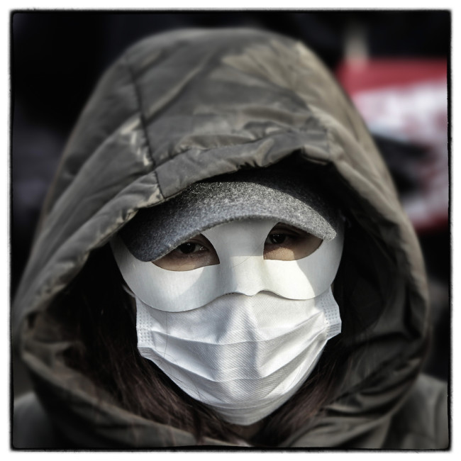 SEOUL, SOUTH KOREA - DECEMBER 05: (EDITORS NOTE: Image was altered with digital filters.) A protester wearing a mask during the anti-government rally on December 5, 2015 in Seoul, South Korea. Demonstrators gathered on the streets of Seoul to protest against the government's decision to adopt new history textbooks and reform the labor market. Liberal civic groups decided to proceed the protest in the central Seoul despite a prohibition order from the police. (Photo by Chung Sung-Jun/Getty Images)
