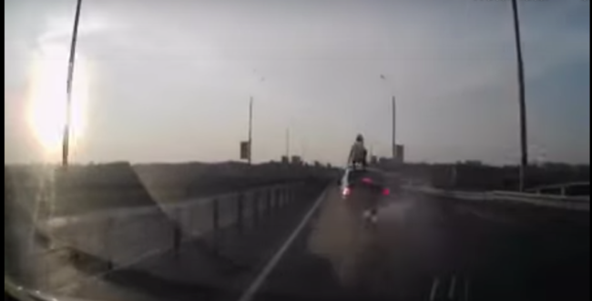 Video: motorcyclist accidentally somersaults onto car roof at speed